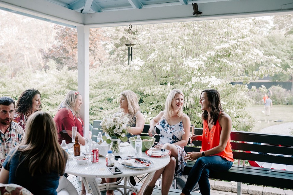 women chatting and laughing on large outdoor porch