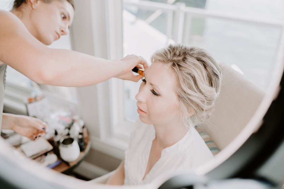 woman having makeup done by makeup artist