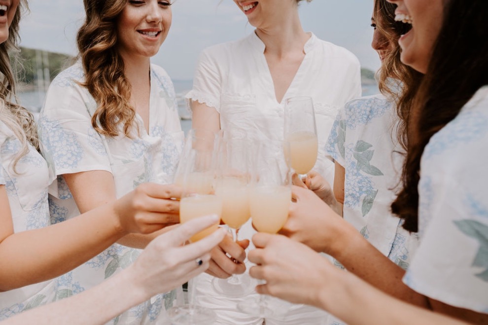 bridesmaids cheers with mimosas on sunny day