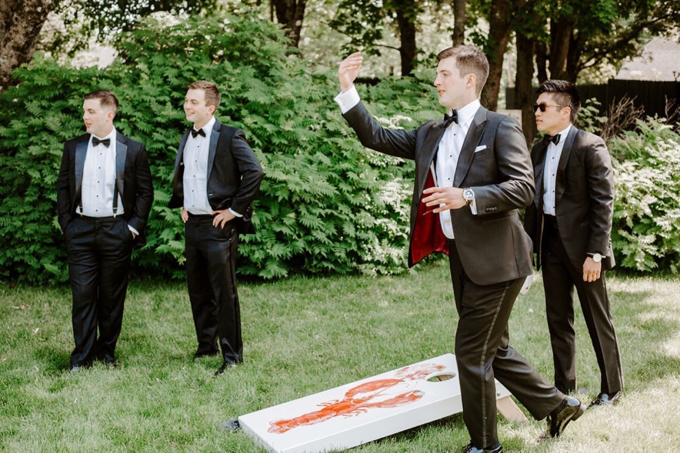 groom and groomsmen playing lawn games outside