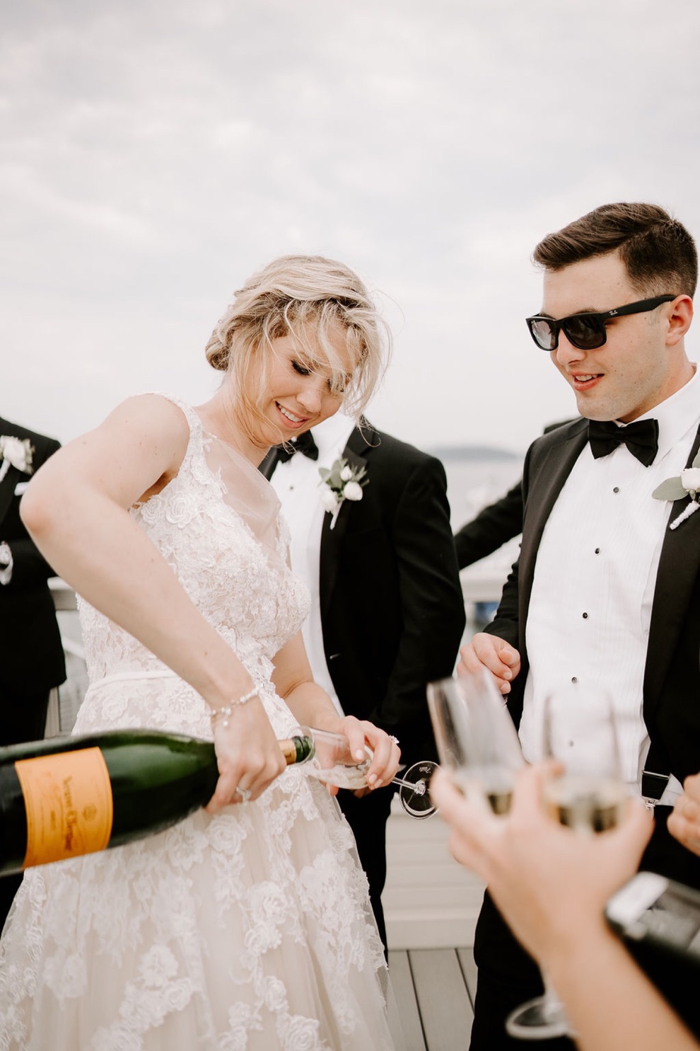 bride and groom smiling and pouring champagne for guests