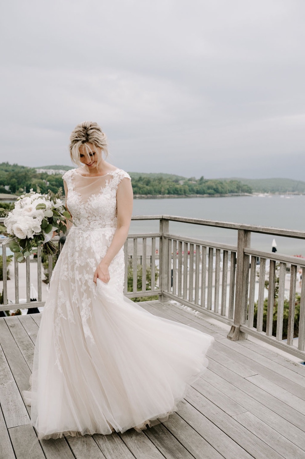 bride twirls on balcony overlooking ocean