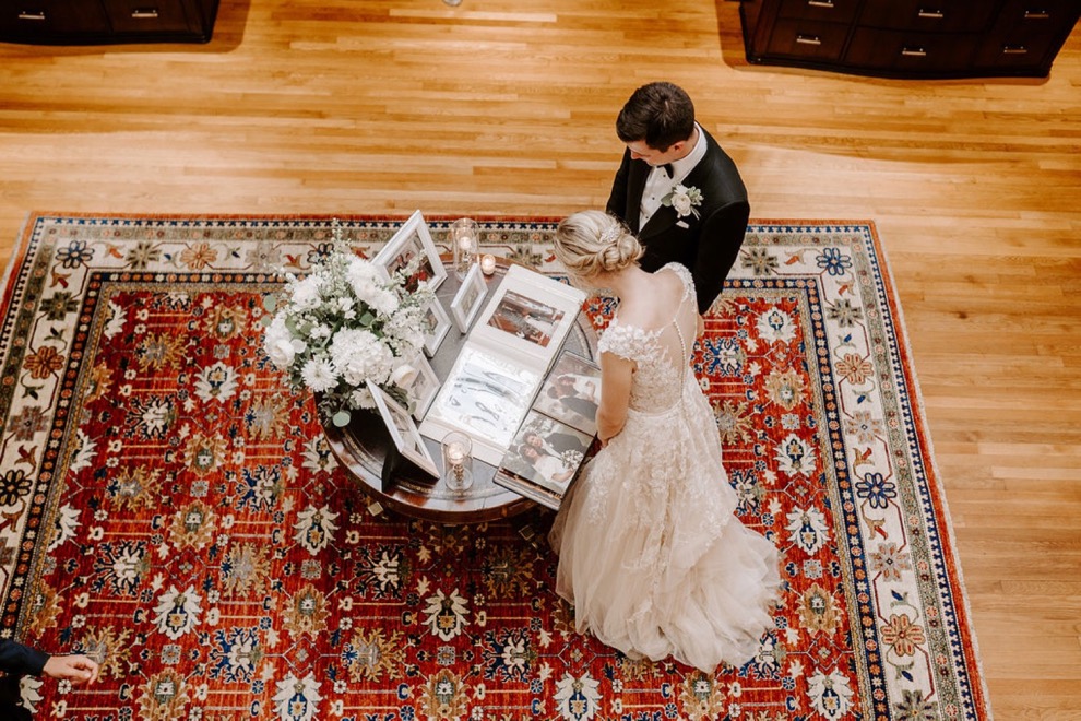 bride and groom read through wedding guest book