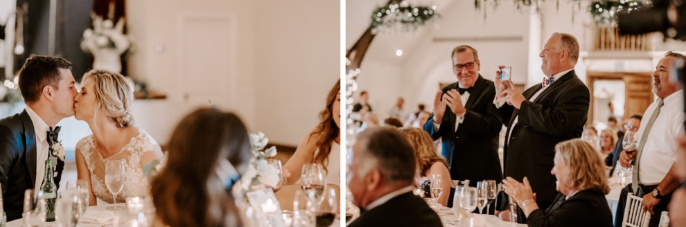 bride and groom kiss during speech at wedding reception