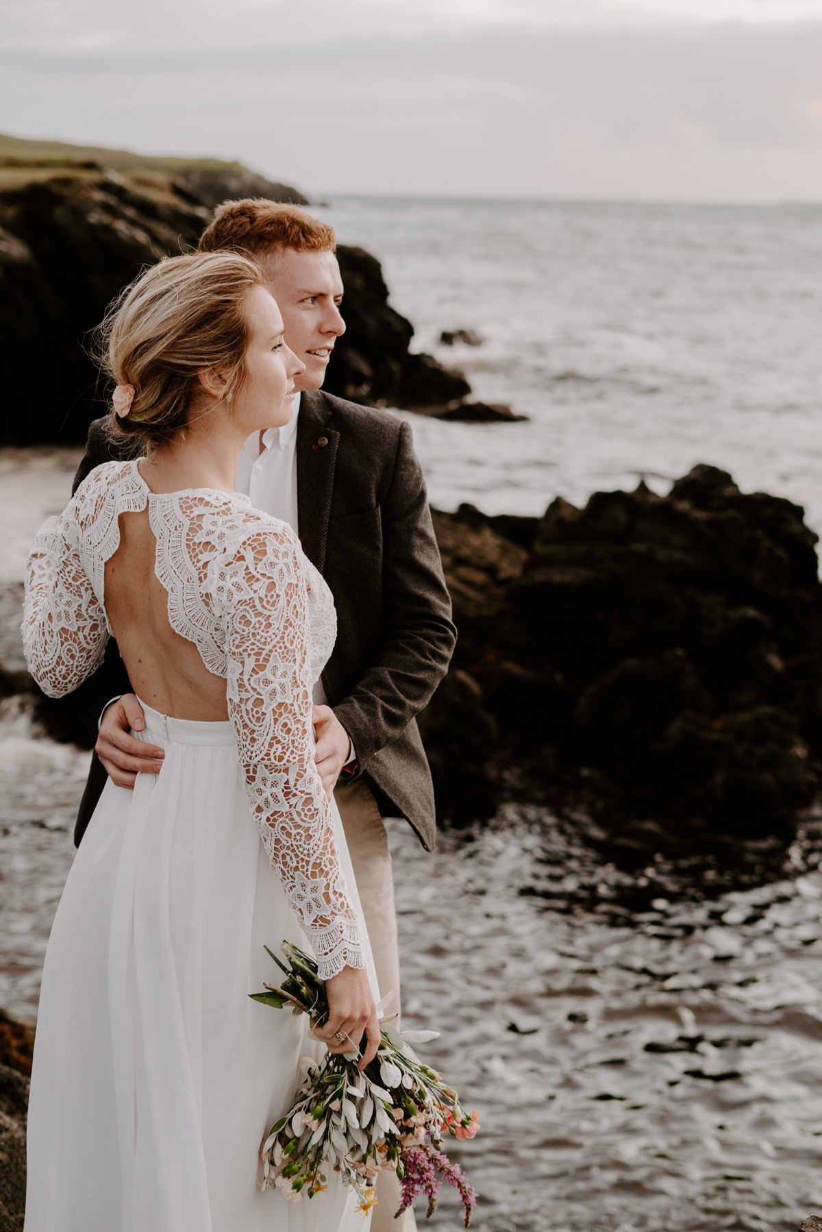 bride and groom looking out toward ocean