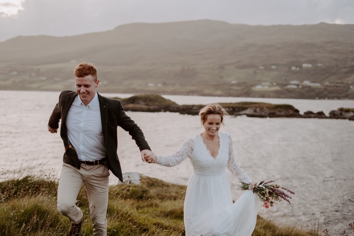bride and groom running along Irish coast