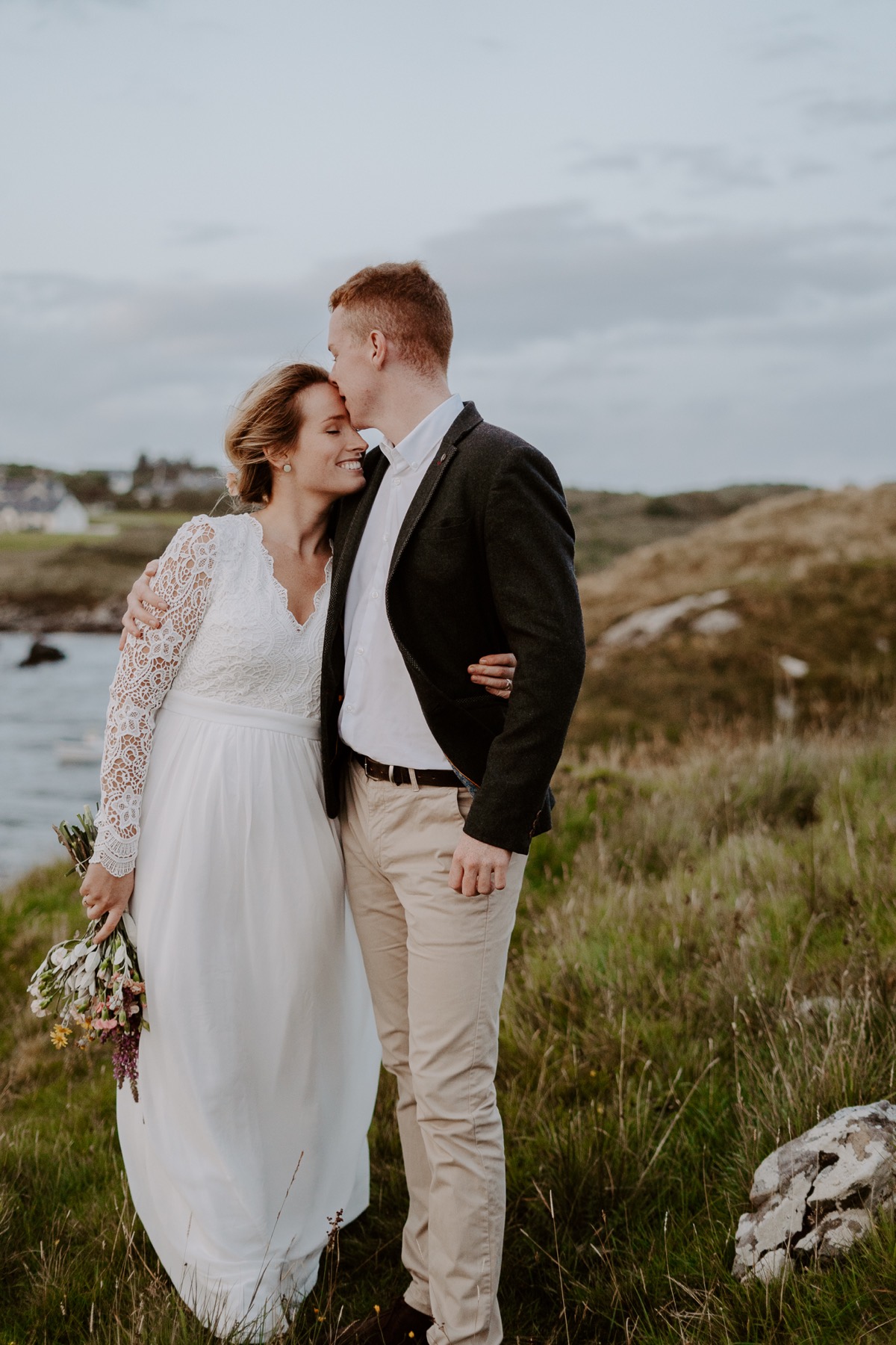 bride and groom holding each other in Irish countryside