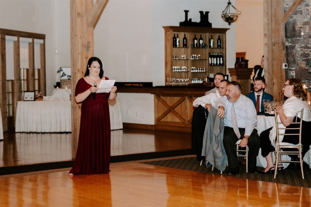 maid of honor in maroon dress gives speech