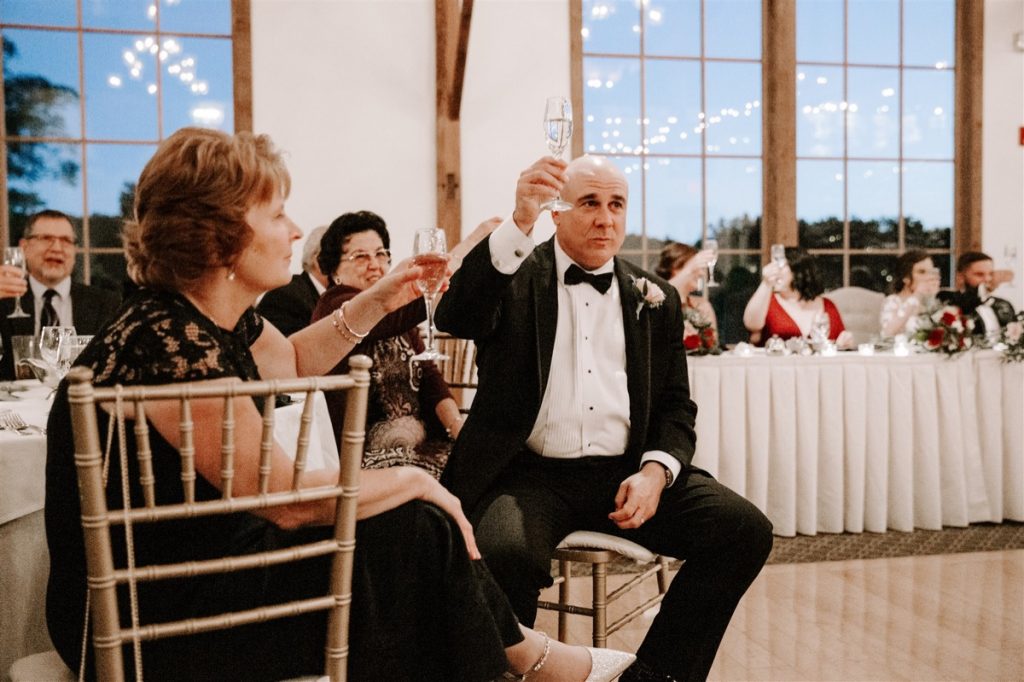 parents of the bride raise a glass to toast daughter's marriage